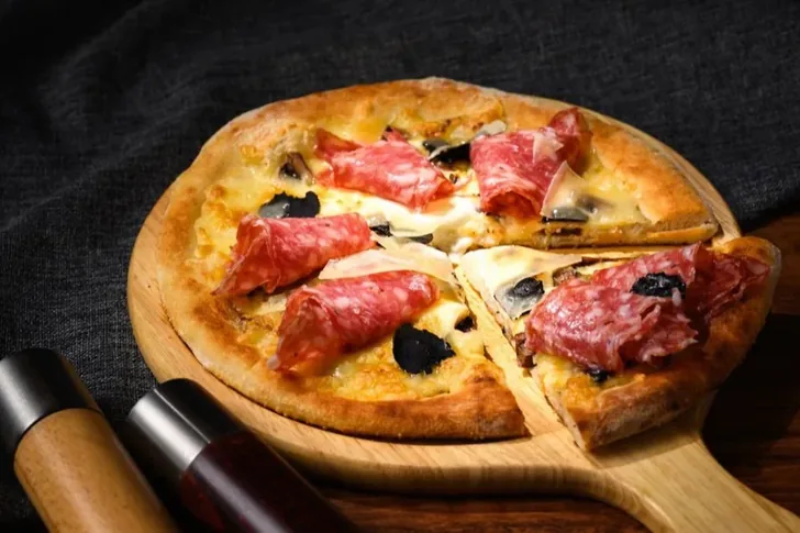Pizza topped with sliced dry-cured pork.
